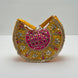 Decorative handbag with yellow, pink, and gold colors on a white background