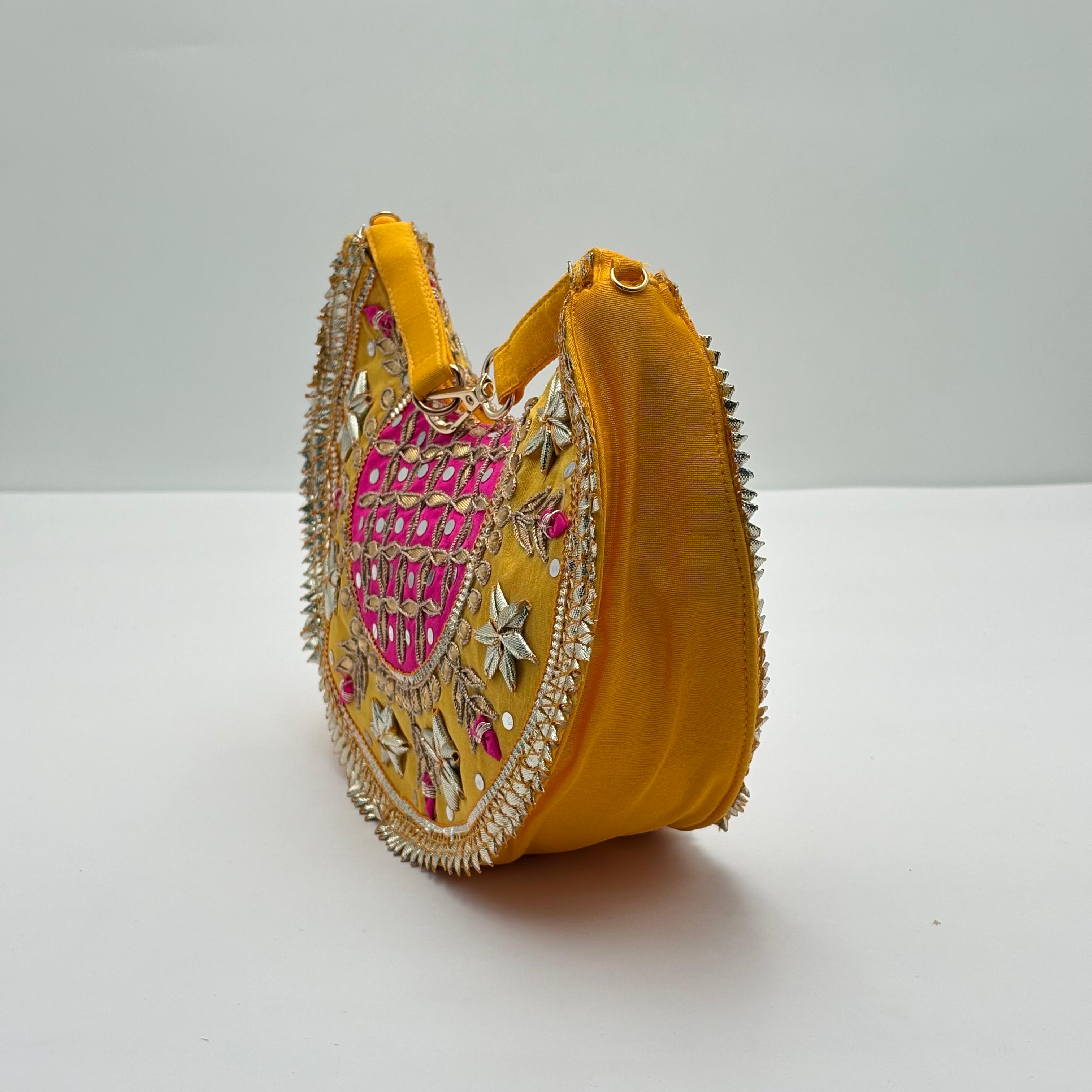 Yellow handbag with intricate embroidery on a white background