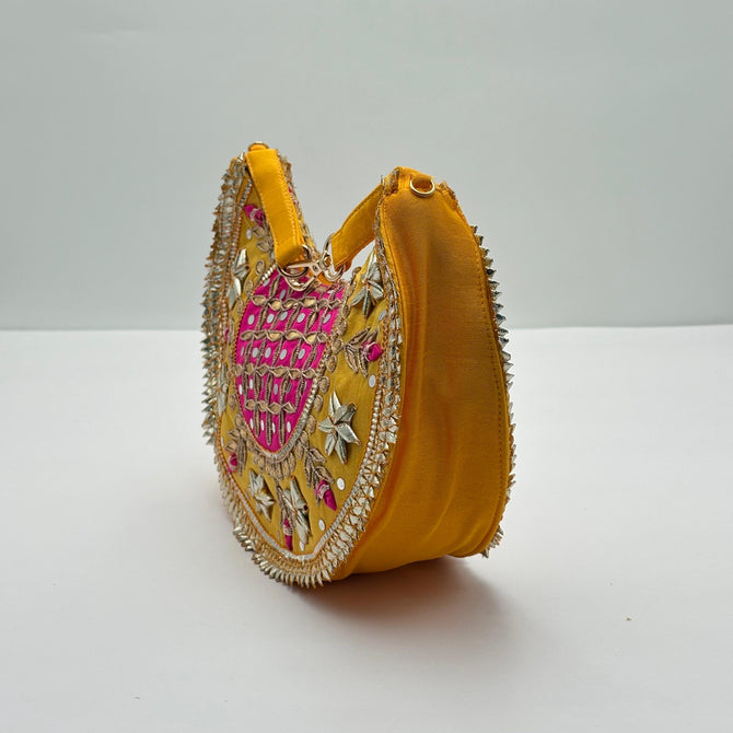 Yellow handbag with intricate embroidery on a white background
