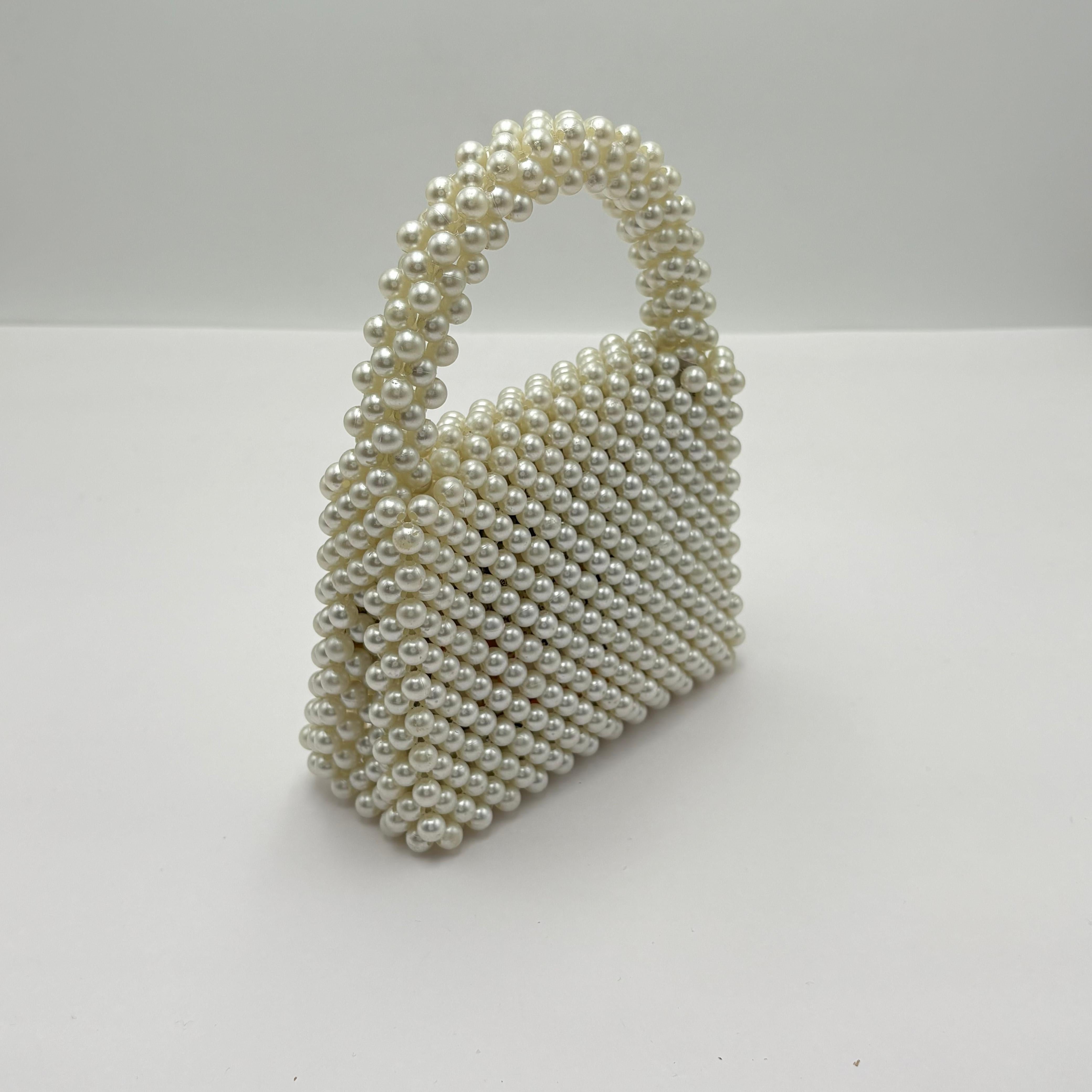 Pearl-handled handbag on a white background