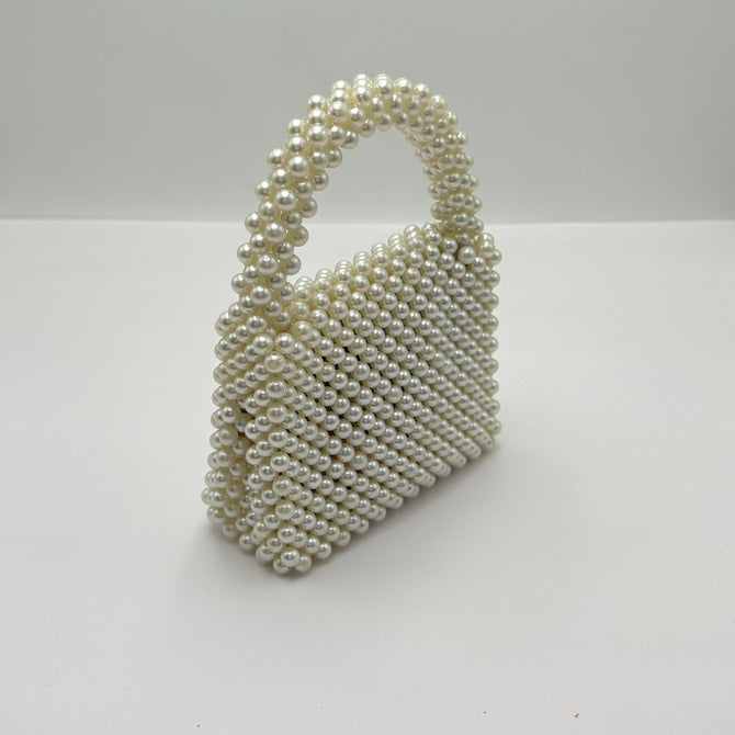 Pearl-handled handbag on a white background
